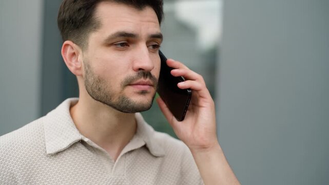 Close up young serious Caucasian business man talking mobile phone male talk call in city businessman executive communicate smartphone corporate conversation manager guy discuss work with telephone