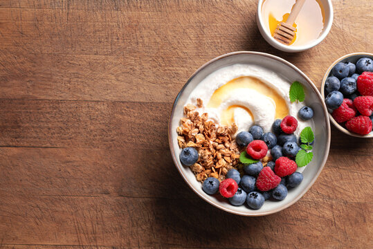 Granola bowl with greek yogurt, berries and honey for healthy breakfast.