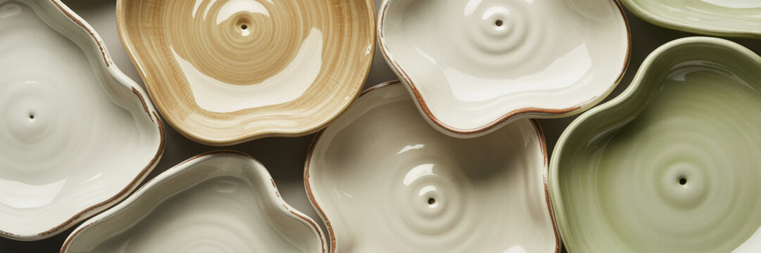 Handcrafted ceramic bowls in pastel colors, irregular shaped pottery set, matte texture tableware, earthy tones stoneware collection, top view of artisanal dishware for serving food, copy space