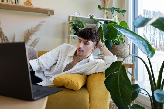 Young man relaxing watching laptop at home