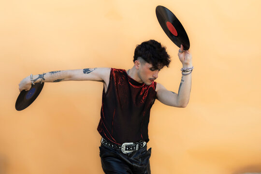 Stylish person dancing holding vinyl records celebrating music