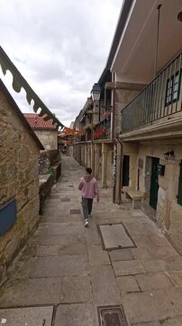 Person exploring the narrow cobblestone streets of Combarro village in Galicia Spain
