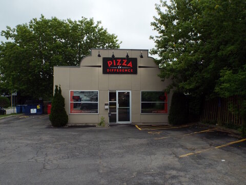 Gatineau, Quebec, Canada &ndash; June 26, 2026: A "Pizza La Difference" restaurant building stands with an empty parking lot in front and green trees on either side at 160 Bd Lorrain.