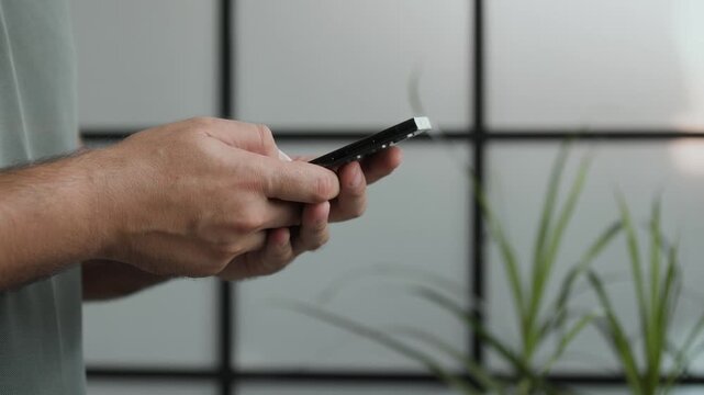 Profile view of man hands typing and swiping on smartphone in slow motion