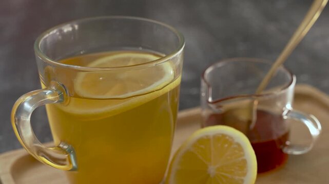 Honey Lemonade in a glass on a table on a wooden tray.