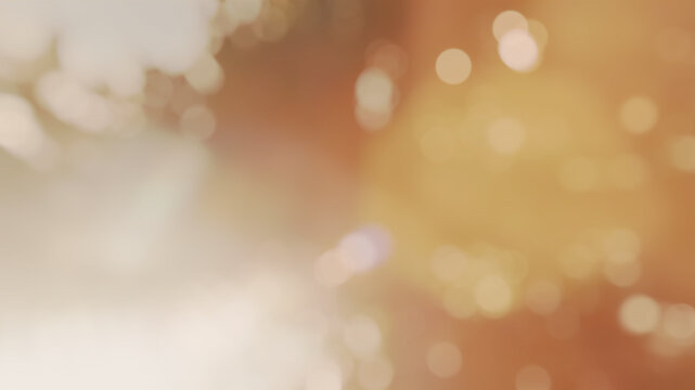 Abstract warm golden blurred bokeh light background with soft sun glare for festive party backdrop or autumn design