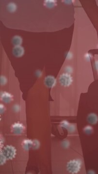 Animation of covid cells over male doctor holding screen with medical data processing