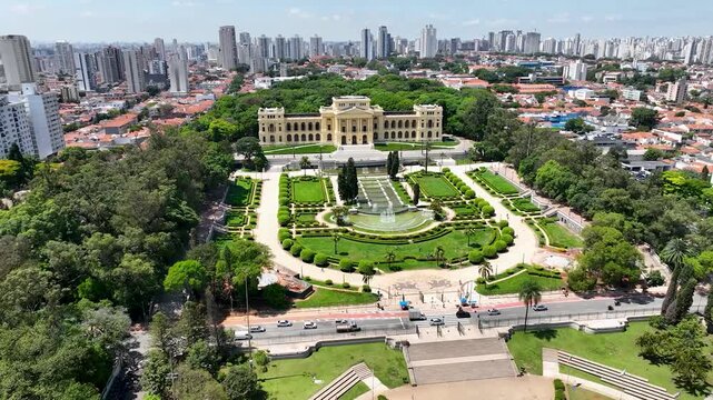 S&Atilde;O PAULO, BRASIL - AGOSTO DE 2026: Vista a&eacute;rea ampla do hist&oacute;rico Museu do Ipiranga, com seus jardins sim&eacute;tricos, fontes de &aacute;gua e o horizonte denso da cidade ao fundo sob a luz do dia