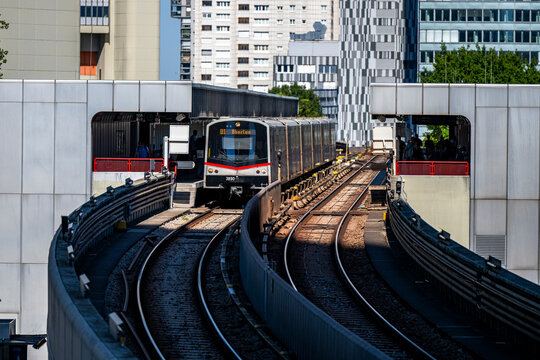Vienna, Austria - August 14, 2026: U-Bahn U1 subway train departing Kaisermuehlen station against the backdrop of modern high-rise architecture in Donau City.