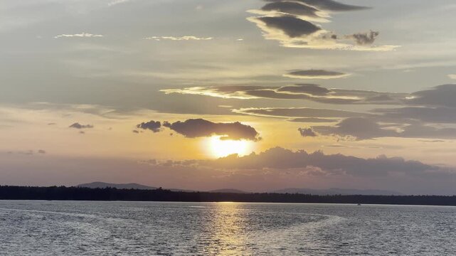 Serene Sunset Scene on the Water with Distant Mountains