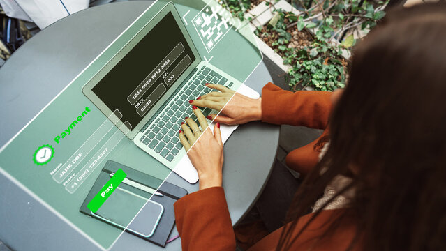 User makes an online payment using a laptop at a table in a cafe