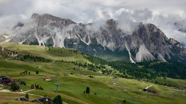 A hiking journey through Val Gardena toward Seceda, featuring open grasslands, traditional mountain chalets, and views of the Odle range.