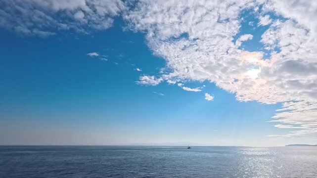 Tranquil seascape background footage featuring central glowing sun, sunbeams, and atmospheric horizon haze