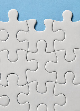 Close up of white puzzle pieces on blue background