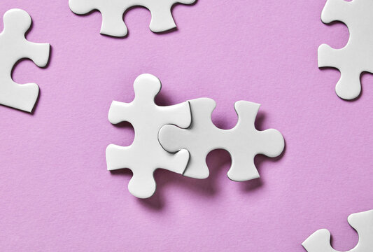 Two connected puzzle pieces with scattered pieces