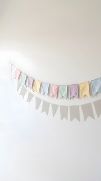Pastel colored party flag bunting decoration hanging on white wall
