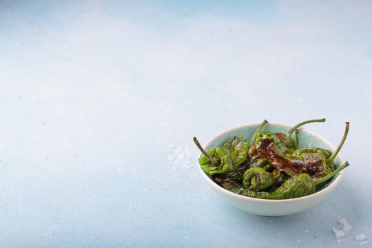 Padron peppers fried bowl sea salt light blue background appetizer Spanish copy space