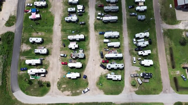 Geometric campground pads display mobile travel trailers along Fort Velasco Drive resort grounds. Neat parking stalls support vacationing coastal tourists, Surfside Beach, Texas