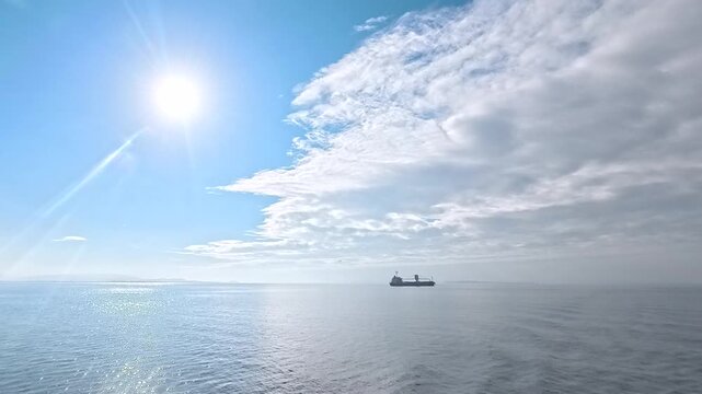 Cinematic real-time wide angle video of sparkling golden sun path reflection over calm ocean