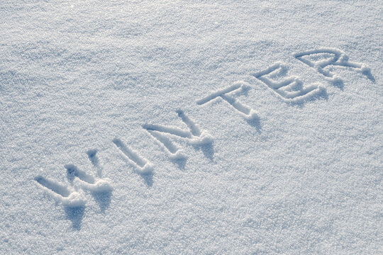 Word Winter handwritten in snow, seasonal background
