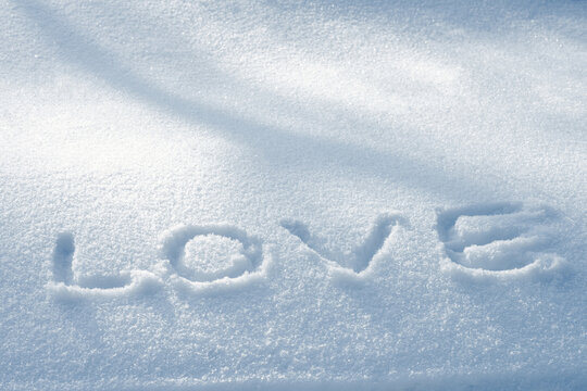 Word Love handwritten in snow, romantic winter concept