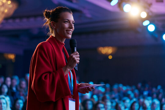 Confident Businesswoman Speaking with Microphone at Conference