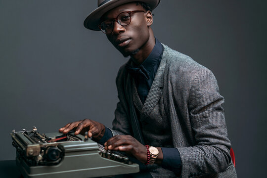 Stylish Man in Vintage Suit Using Retro Typewriter