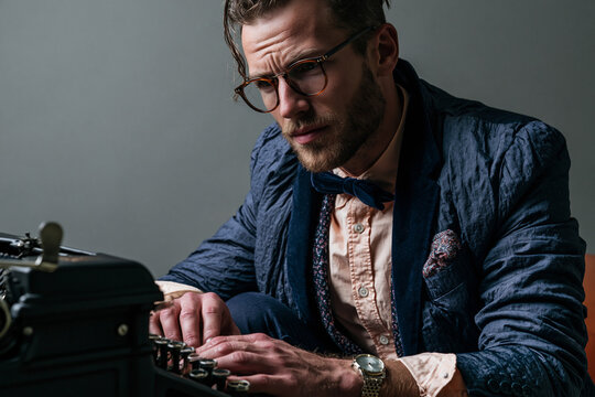 Focused Stylish Writer Working on Vintage Typewriter