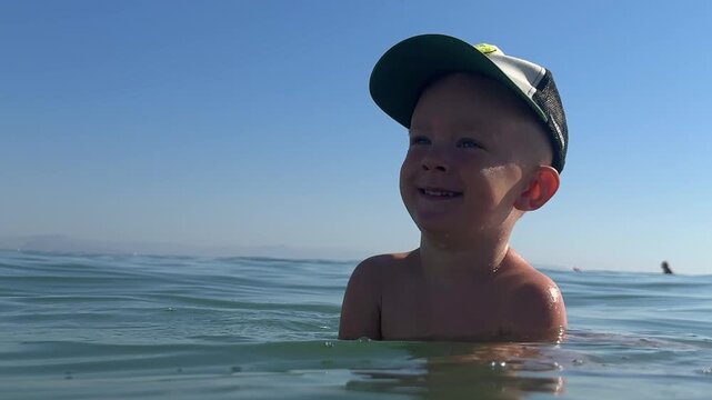 Little boy enjoying swimming in the sea. 4k