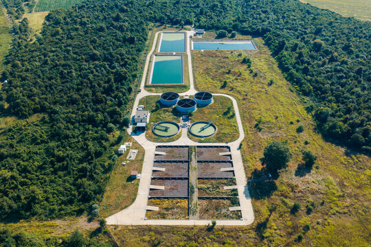 Aerial view of the Telavi Waste Water Treatment Facility featuring circular clarifiers and rectangular treatment tanks surrounded by lush forest in Kondoli, Kakheti, Georgia.