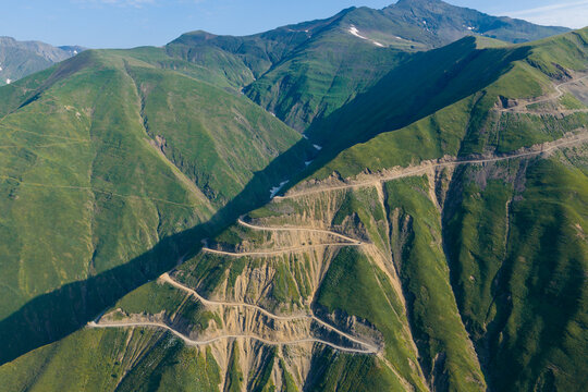 Aerial view of the winding Abano Pass mountain road carved into the steep green slopes of the Caucasus Mountains in Akhmeta Municipality, Kakheti, Georgia.