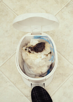 Open trash can on kitchen floor.