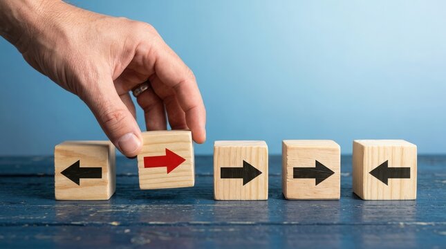 Hand placing a wooden block with a red arrow pointing right