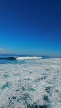Vertical video. FPV Drone Chasing Breaking Wave at Nyang Nyang Beach, High Speed Flight Along Ocean Crest And White Foam, Surf Adventure And Endless Tropical Freedom