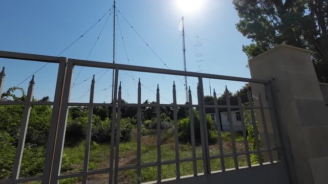Radio Communication Antenna Tower in a Green Landscape Under Clear Blue Sky