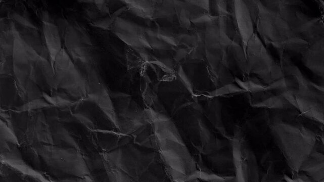 crumpled black paper texture background animation, for creative projects, video overlays and bold artistic backgrounds. Abstract textured backdrop for creative projects.