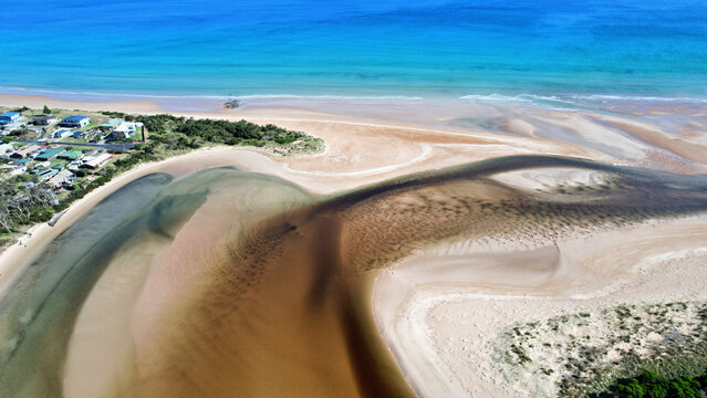 Brown river delta and blue sea - a fairy tale landscape in Tasmania, view from above.