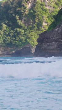 Vertical video. Ocean Waves and Rocky Coastline at Kelingking Beach on Nusa Penida Island Bali Indonesia