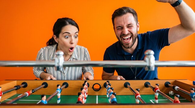 Coworkers playing foosball during break in a vibrant office setting  