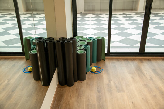 Rolled fitness yoga mats standing in corner of gym fitness studio