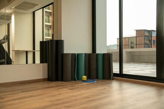 Rolled fitness yoga mats standing in corner of gym fitness studio