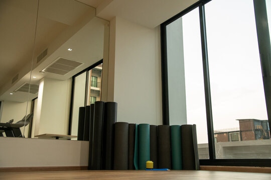 Rolled fitness yoga mats standing in corner of gym fitness studio