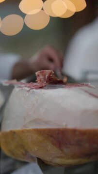Professional chef slicing cured spanish ham