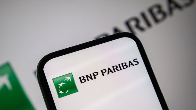 BNP Paribas green logo on phone screen with blurred backdrop.