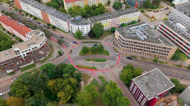 Aerial view of traffic around Pfalzer Platz near university and Nordpark in Magdeburg, Germany. Urban roads, tram tracks, cycle lanes, cars and modern buildings shape daily city transport scene