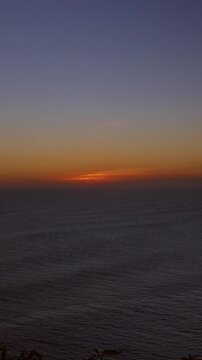 Vertical video. Colorful Twilight Sky Above Calm Indian Ocean Near Uluwatu Coastline After Sunset, Tranquil Evening Seascape, Natural Beauty And Peaceful Atmosphere