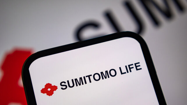 Sumitomo Life logo viewed on smartphone display with blurred corporate emblem in background.