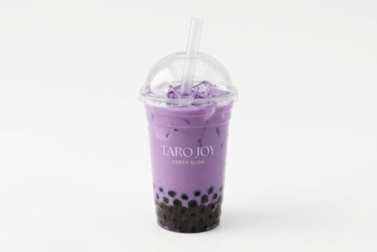 Delicious Purple Taro Milk Tea with Black Boba Pearls and Ice in a Clear Cup Isolated on White