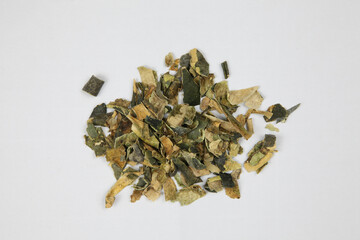 Pile of dried herbal leaves isolated on white background © LamQuang
