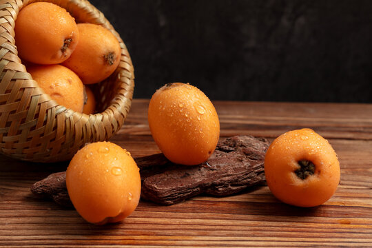 Fresh loquats in a basket on rustic wooden table